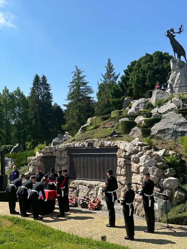 An honour guard stands with the casket below the caribou statue at the Beaumont-Hamel memorial