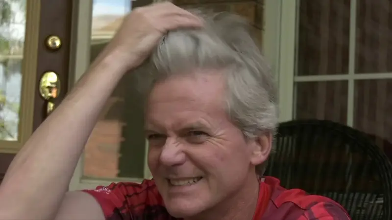 Still from Running the Risks: a veteran marathon runner laughs during an interview
